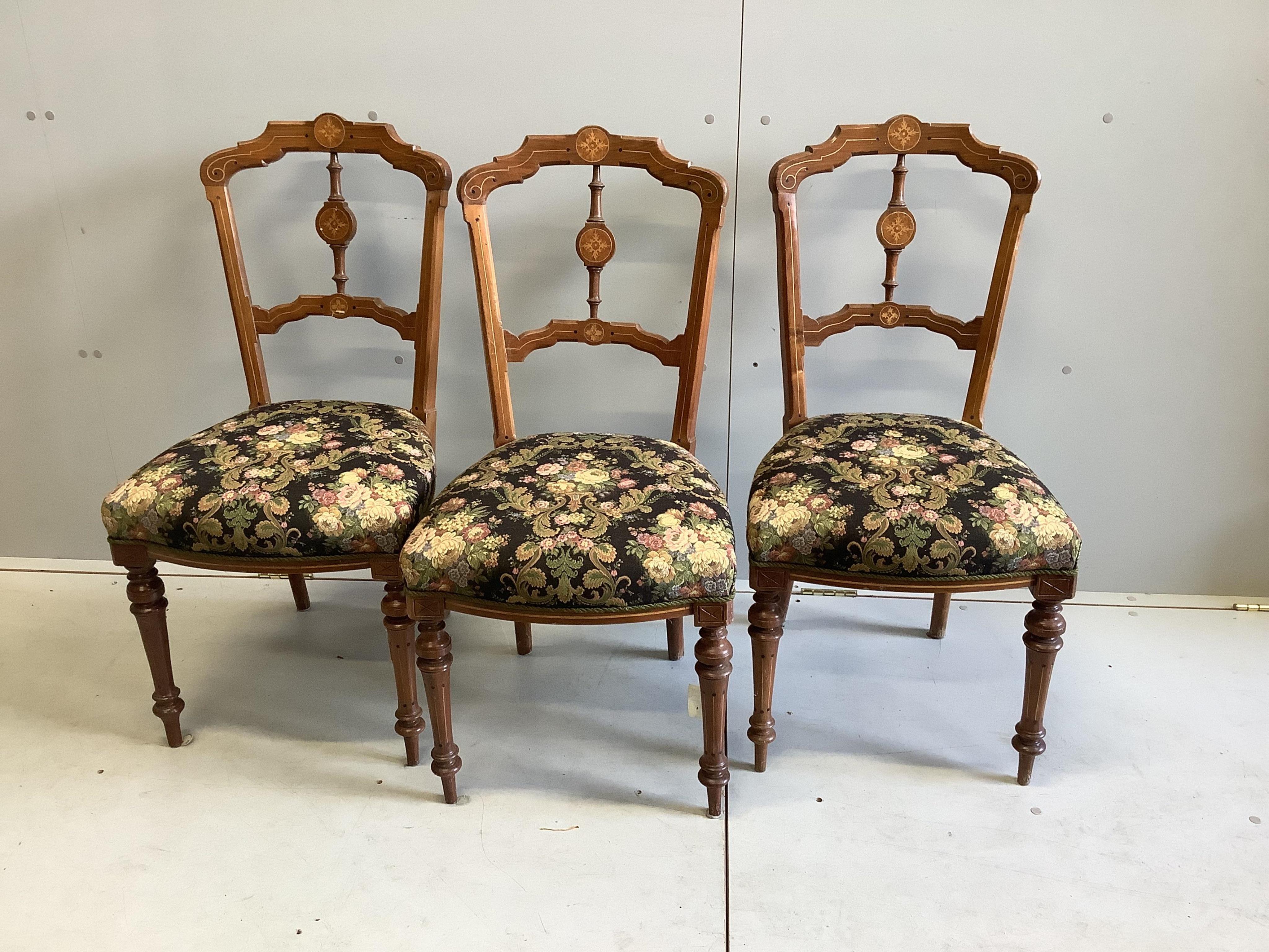 A late Victorian inlaid walnut settee, width 154cm, depth 64cm, height 92cm together with three matching side chairs. Condition - fair